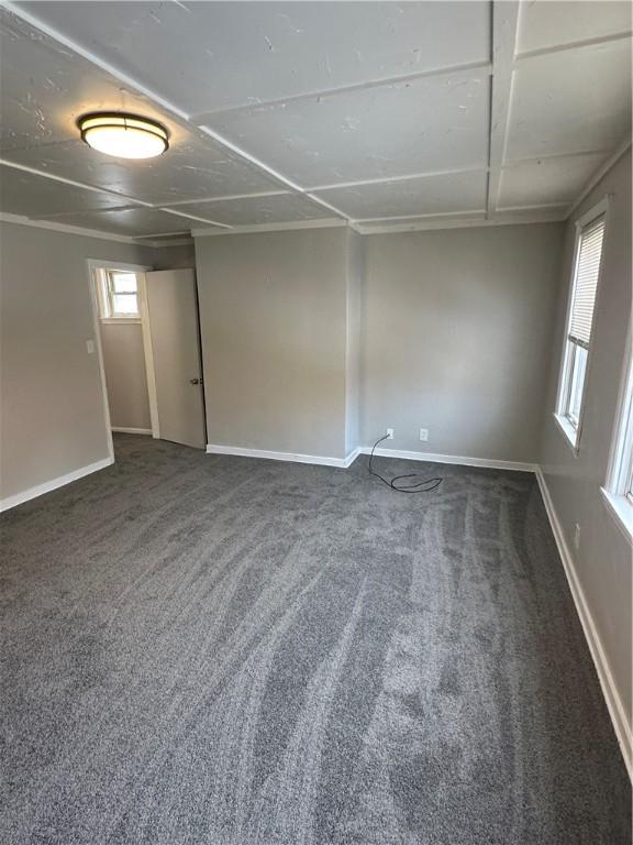 carpeted empty room featuring baseboards