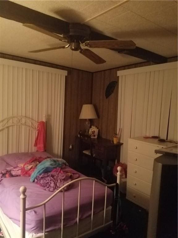 bedroom featuring wood walls and ceiling fan