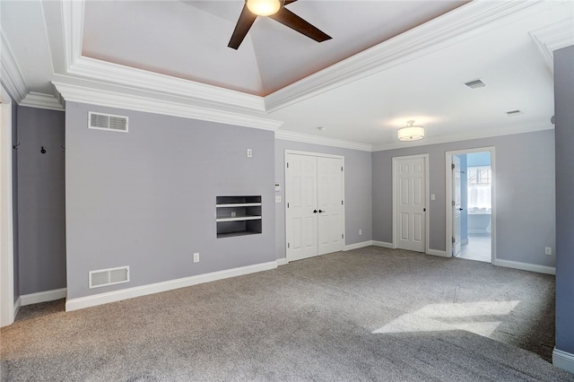 interior space featuring a raised ceiling, visible vents, and crown molding