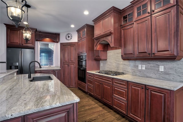 kitchen featuring dark wood-style flooring, a sink, gas stovetop, stainless steel refrigerator with ice dispenser, and tasteful backsplash