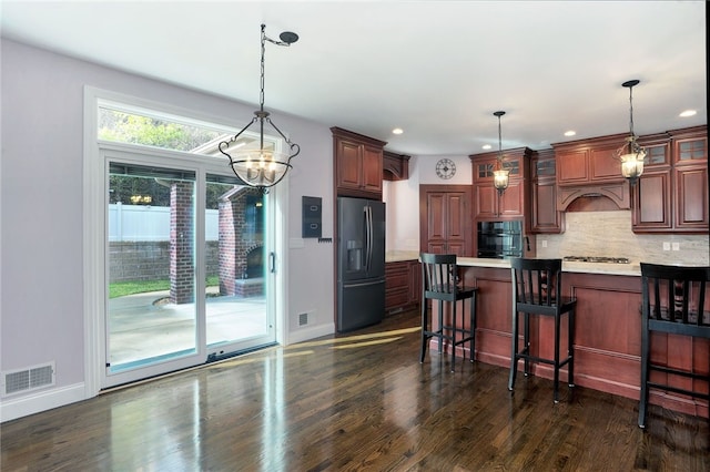 kitchen featuring tasteful backsplash, visible vents, glass insert cabinets, dark wood-style flooring, and black appliances