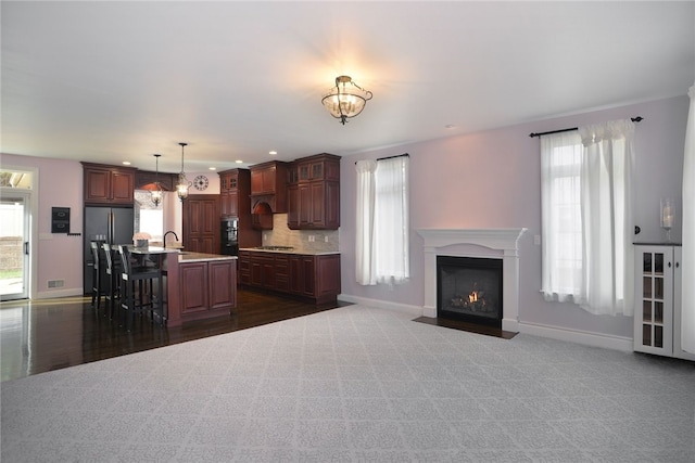 kitchen featuring stainless steel appliances, a breakfast bar, baseboards, light countertops, and decorative backsplash