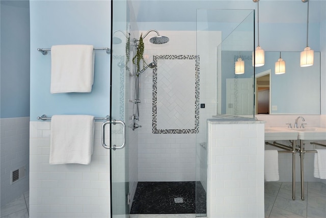 bathroom with a stall shower, wainscoting, and tile walls