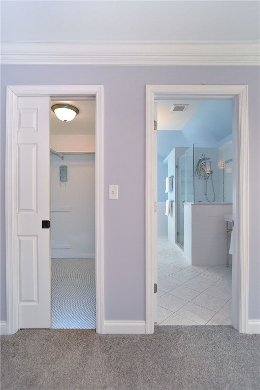 hallway featuring baseboards, visible vents, carpet flooring, and ornamental molding