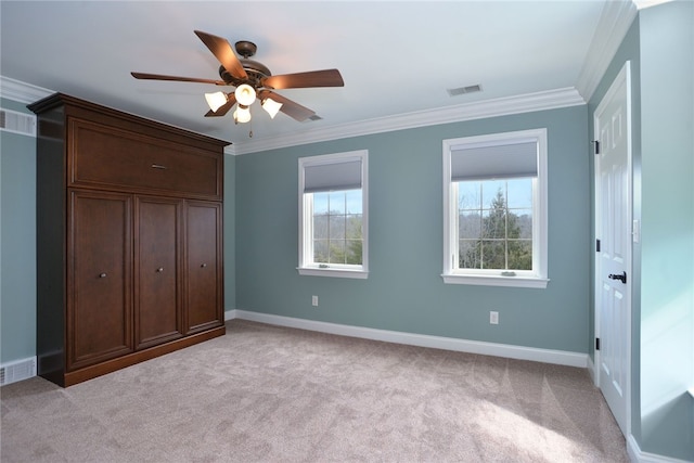 unfurnished bedroom with baseboards, visible vents, crown molding, and light colored carpet