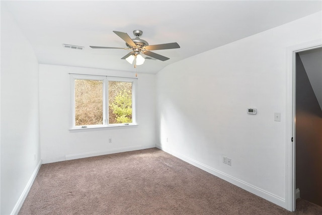 carpeted spare room featuring lofted ceiling, a ceiling fan, visible vents, and baseboards