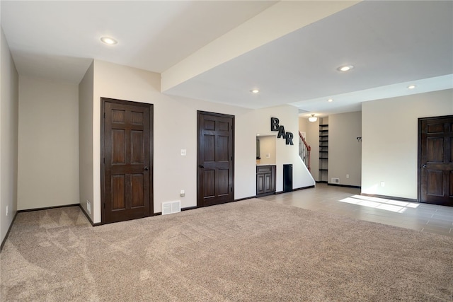 spare room featuring recessed lighting, carpet flooring, visible vents, and stairs