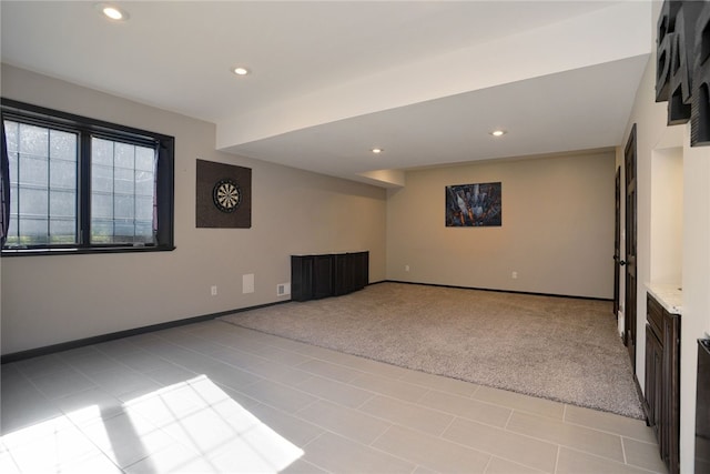 below grade area with light carpet, light tile patterned floors, baseboards, and recessed lighting