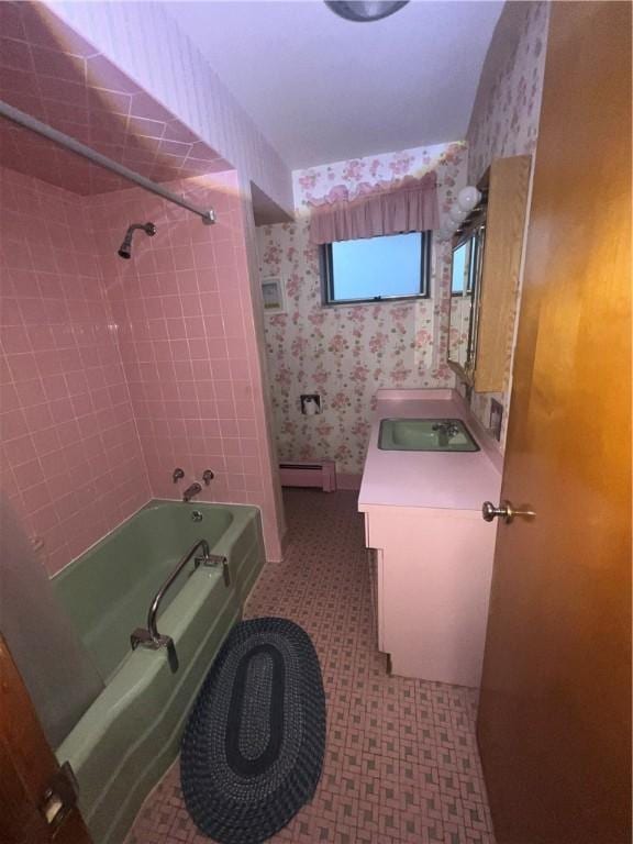 bathroom with a baseboard radiator, vanity,  shower combination, tile patterned floors, and wallpapered walls