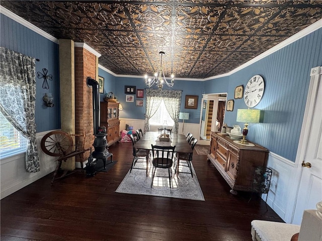 dining room with an ornate ceiling, wood-type flooring, crown molding, and wainscoting