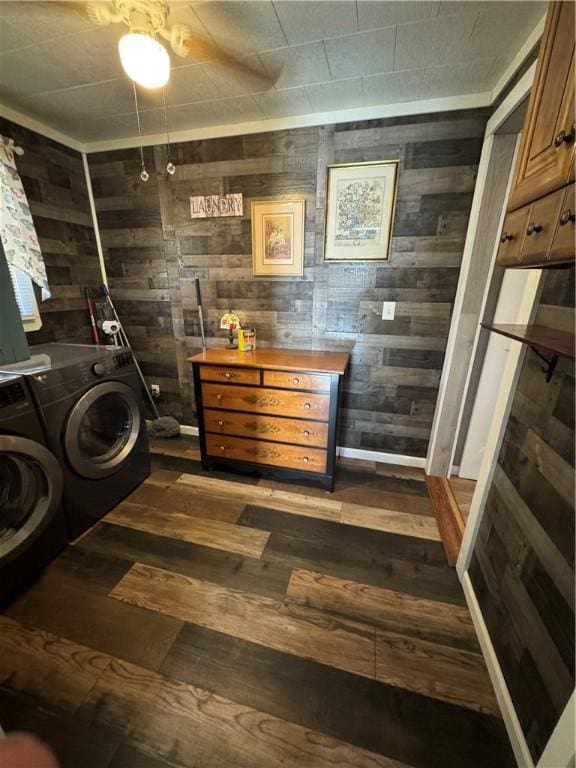 washroom with wood walls, dark wood-type flooring, and independent washer and dryer