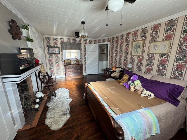 bedroom featuring wallpapered walls, crown molding, and wood finished floors