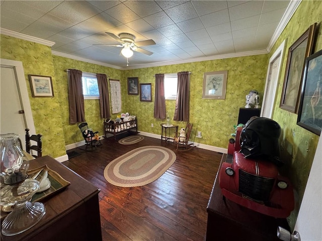 sitting room with wallpapered walls, baseboards, a ceiling fan, wood-type flooring, and ornamental molding