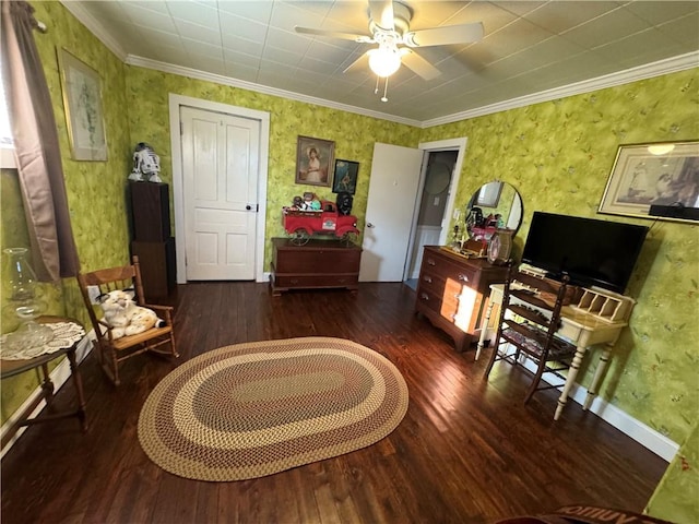 sitting room with crown molding, ceiling fan, wood finished floors, baseboards, and wallpapered walls