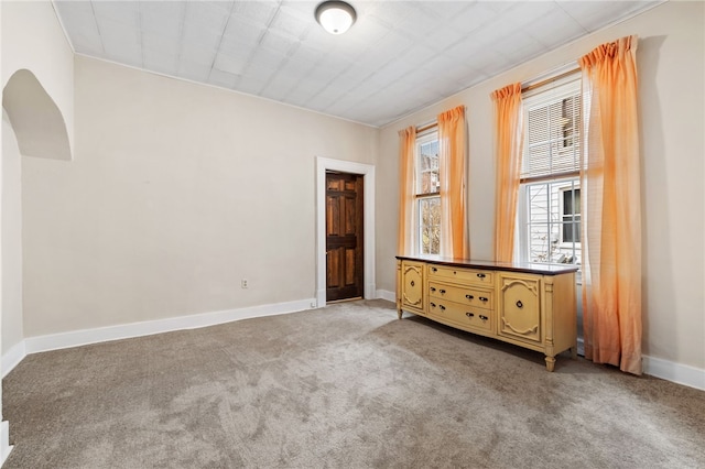 interior space featuring light colored carpet and baseboards