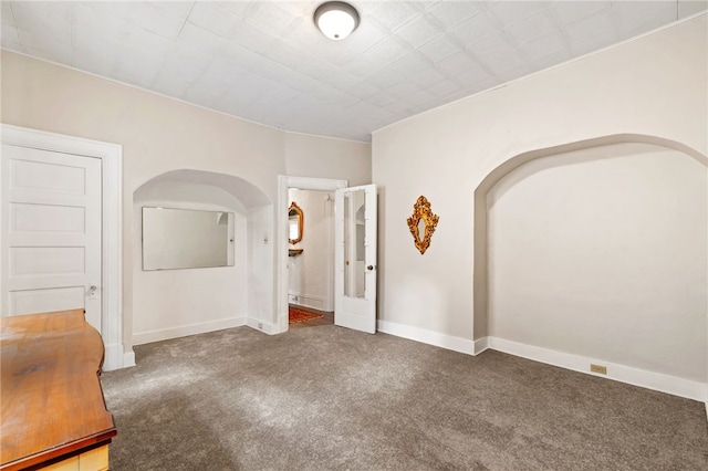 unfurnished room featuring carpet and baseboards