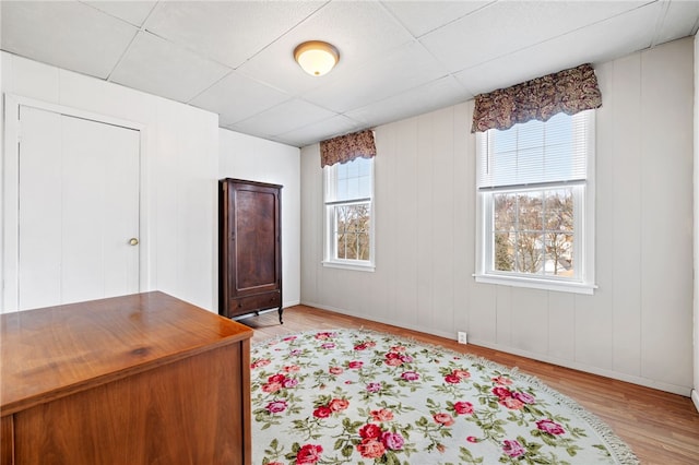 bedroom with a paneled ceiling and light wood-style floors