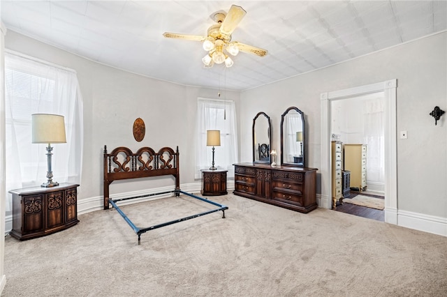 carpeted bedroom featuring connected bathroom, a ceiling fan, and baseboards