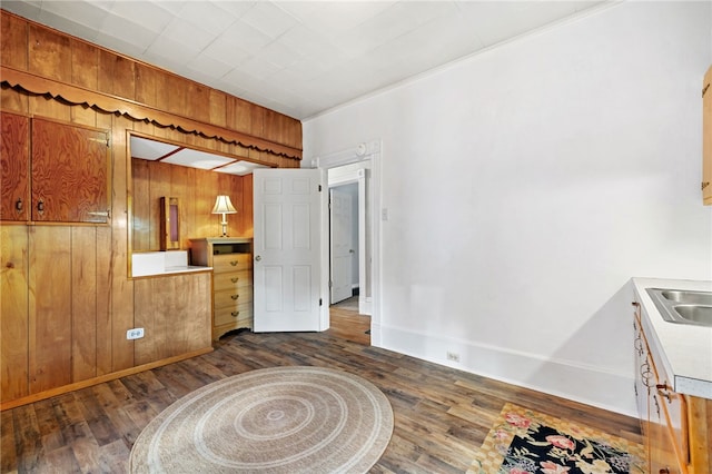 kitchen featuring light countertops, dark wood-type flooring, brown cabinets, and wooden walls