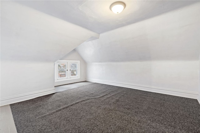 additional living space featuring carpet floors, lofted ceiling, and baseboards