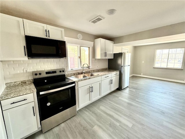 kitchen featuring visible vents, appliances with stainless steel finishes, backsplash, and a sink