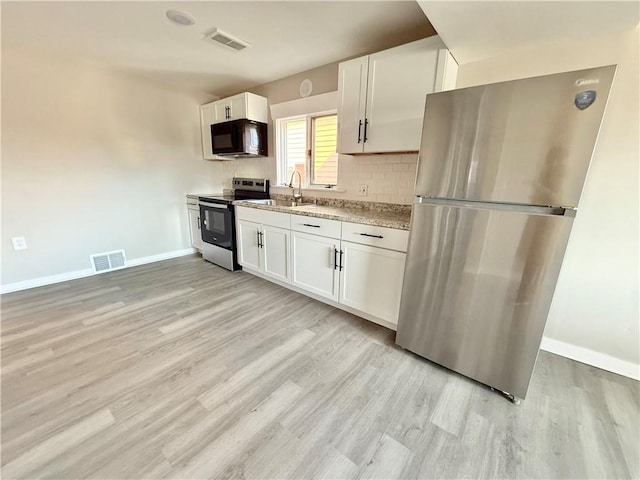 kitchen featuring appliances with stainless steel finishes, backsplash, visible vents, and white cabinets