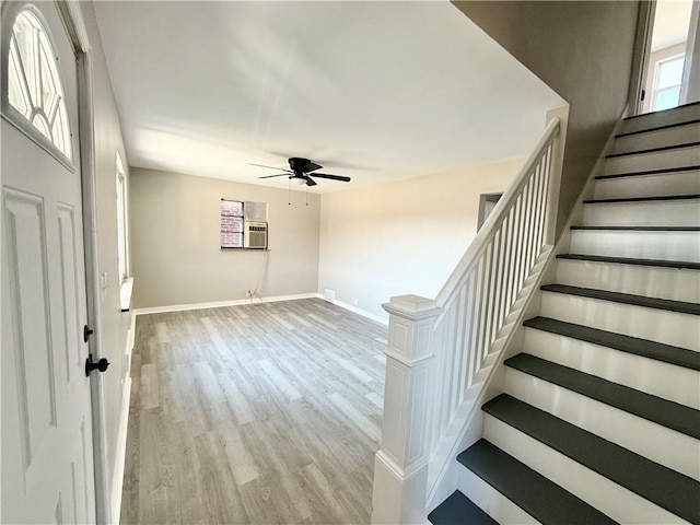 entrance foyer featuring a ceiling fan, stairway, baseboards, and wood finished floors