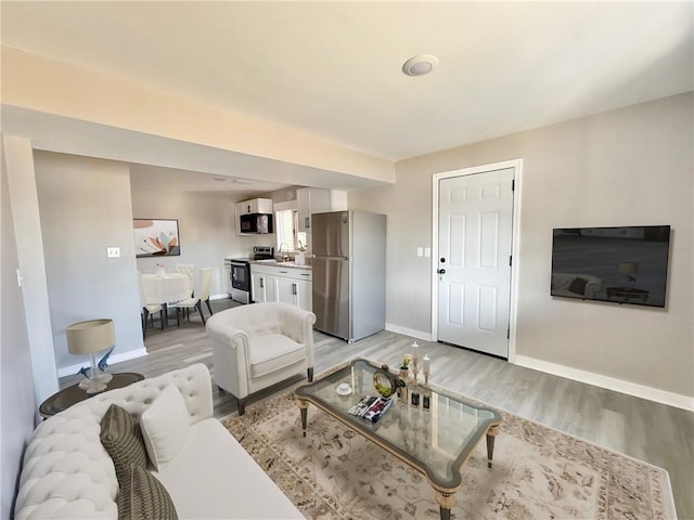 living room with light wood-type flooring and baseboards