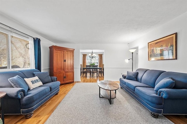 living room with a chandelier and light wood-style flooring