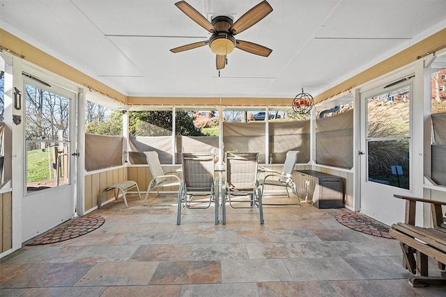 unfurnished sunroom with a ceiling fan