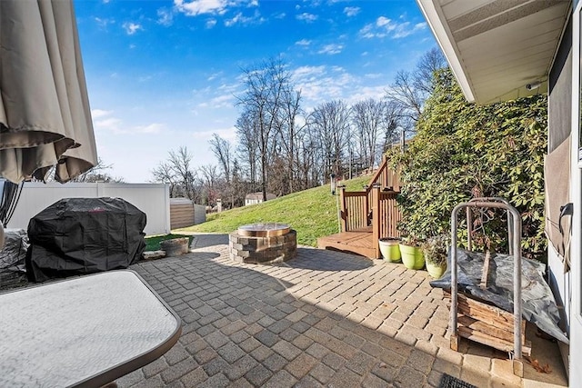 view of patio / terrace featuring an outdoor fire pit, area for grilling, and fence