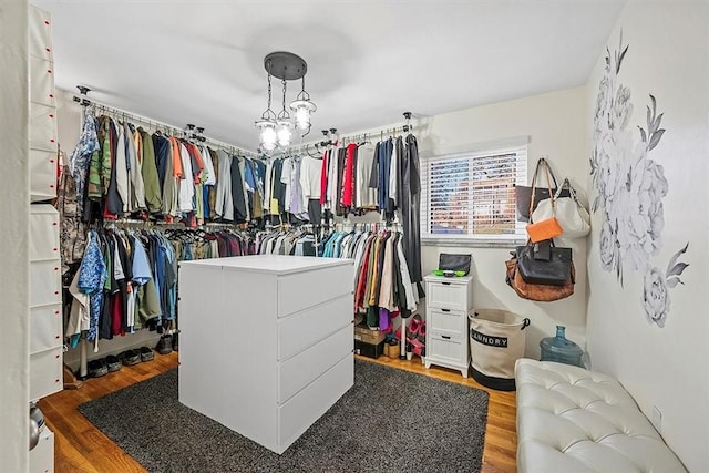 spacious closet featuring light wood-style floors and a chandelier