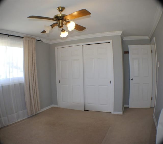 unfurnished bedroom with light carpet, baseboards, ornamental molding, and a closet