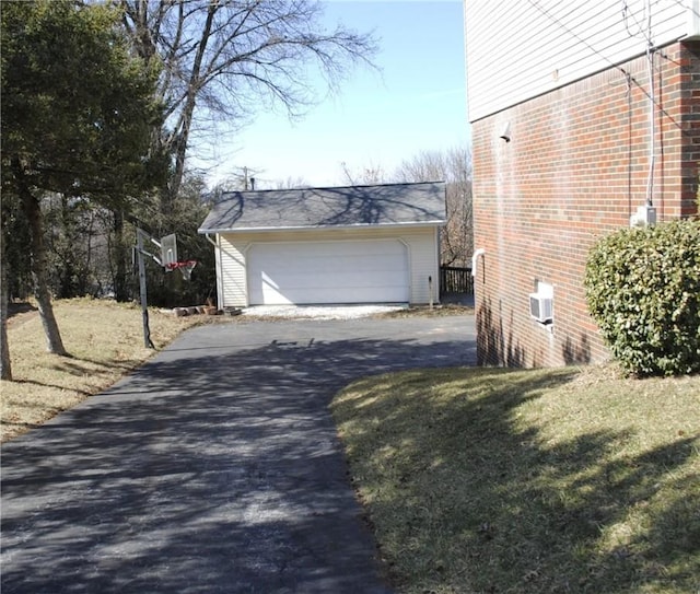 view of property exterior featuring a garage, a yard, an outdoor structure, and brick siding