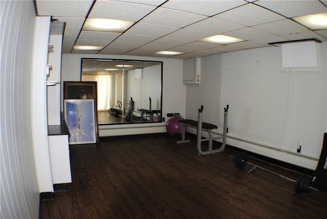 workout area with a drop ceiling and dark wood finished floors