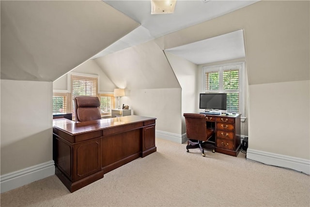 carpeted office space featuring baseboards and vaulted ceiling