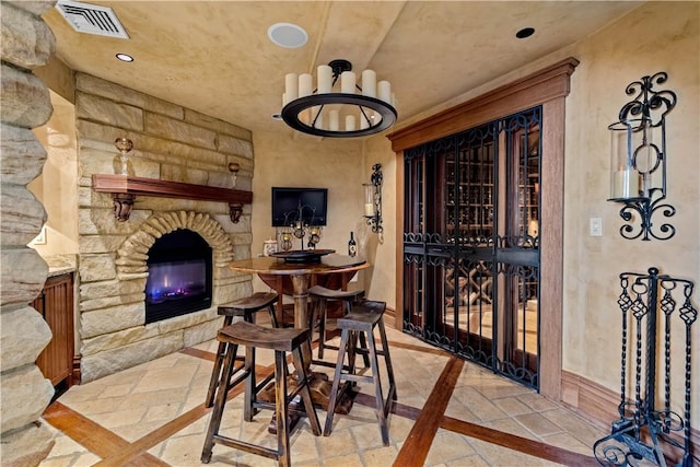 wine cellar featuring recessed lighting, stone tile flooring, visible vents, and a stone fireplace