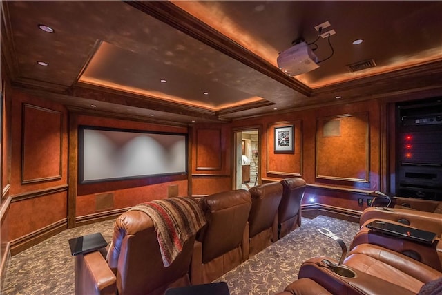 cinema featuring crown molding, a raised ceiling, and carpet flooring