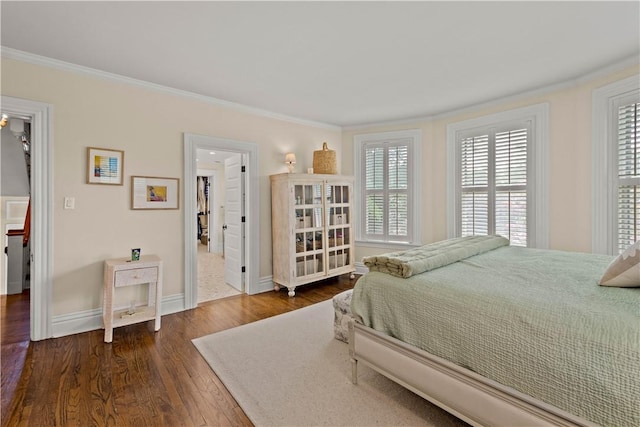 bedroom featuring ornamental molding, dark wood-style flooring, and baseboards