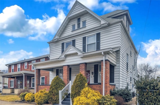 traditional style home featuring a porch and brick siding