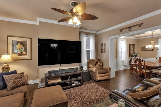 living room featuring ceiling fan with notable chandelier, a wainscoted wall, wood finished floors, and crown molding