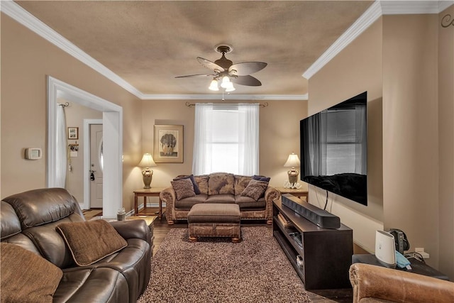 living room with ornamental molding, wood finished floors, a ceiling fan, and baseboards