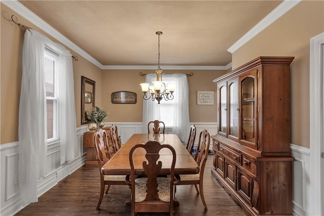 dining room featuring a wainscoted wall, crown molding, dark wood finished floors, and an inviting chandelier