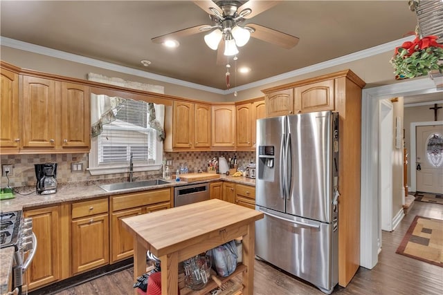 kitchen with a sink, wooden counters, appliances with stainless steel finishes, backsplash, and crown molding