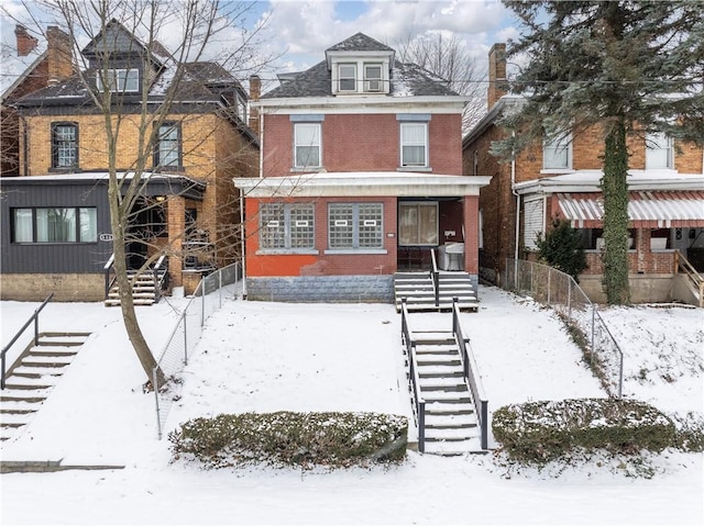 traditional style home with stairway, a porch, and brick siding