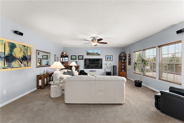 living room featuring light carpet, ceiling fan, and baseboards