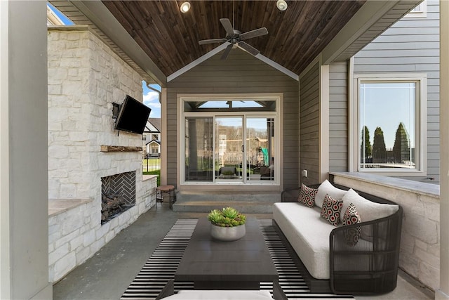 view of patio featuring a ceiling fan and an outdoor living space with a fireplace