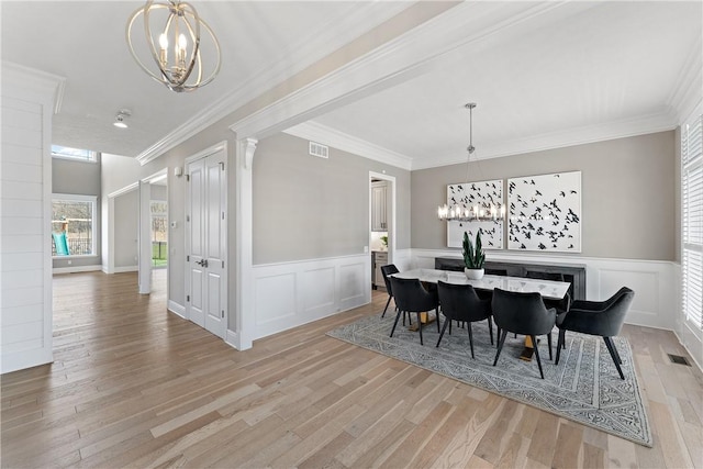 dining room featuring light wood-style floors, visible vents, ornamental molding, and an inviting chandelier