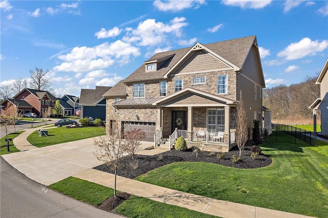 craftsman house featuring a porch, a standing seam roof, stone siding, driveway, and a front lawn