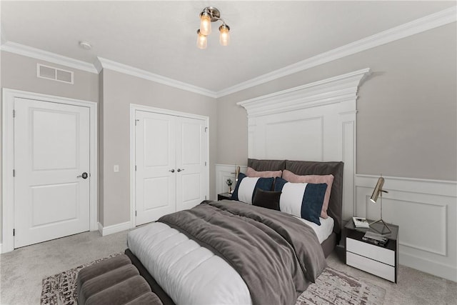 carpeted bedroom featuring a wainscoted wall, ornamental molding, a closet, and visible vents